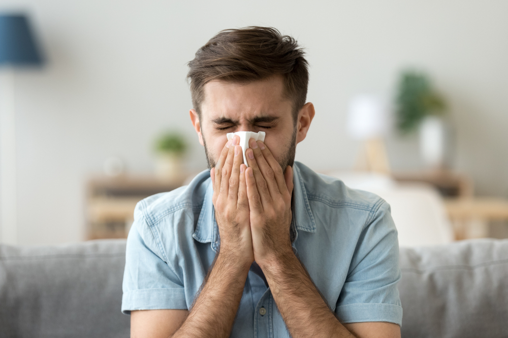 man blowing his nose.